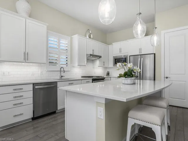 Kitchen is spacious and timeless with white cabinetry, island with plenty of storage, stainless steel whirlpool appliances, and pantry for additional storage.