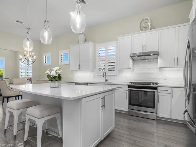 Plantation shutters, designer pendant lighting, and beveled subway tile give this kitchen a classic look.