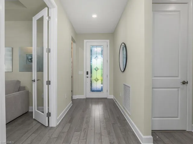 Welcoming foyer includes impact front door with decorative glass, and hardwood flooring.