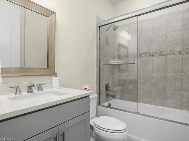 Guest bath with custom mirror, glass shower enclosure, and custom tile work.
