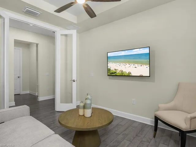 Den features plantation shutters, hardwood flooring and tray ceiling.