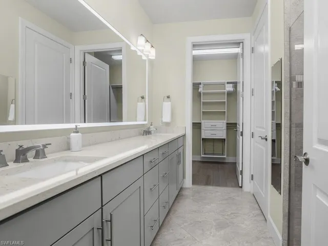 Owner bath features frameless glass shower, dual sinks, plenty of cabinet storage space, and a large walk-in closet with custom built in shelving.