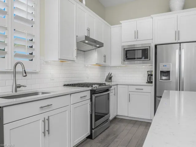 Added kitchen features include white quartz counters, soft close cabinets with pull-out drawers, stainless steel appliances, and natural gas stove/cooktop.