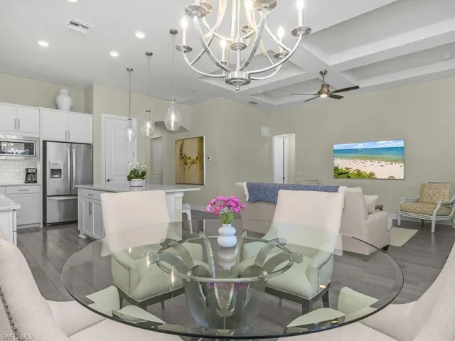 Dining room features plantation shutters, designer lighting, and gorgeous engineered hardwood flooring.