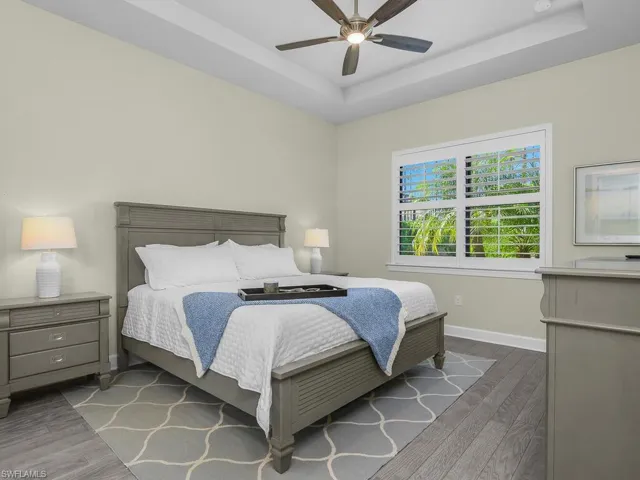 Owner suite is spacious and includes tray ceiling, hardwood flooring, and ensuite bath.