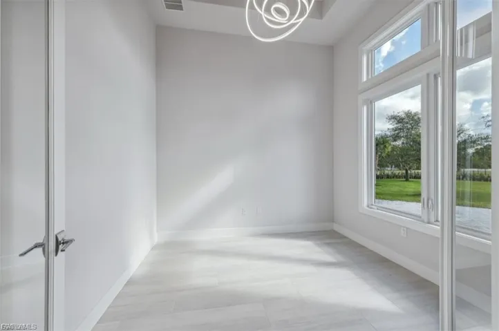 Empty room featuring baseboards and hanging lights