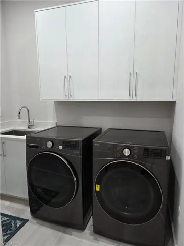 Laundry area with cabinet space and separate washer and dryer