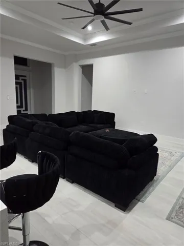 Living room with ceiling fan, recessed lighting, crown molding, and a raised ceiling