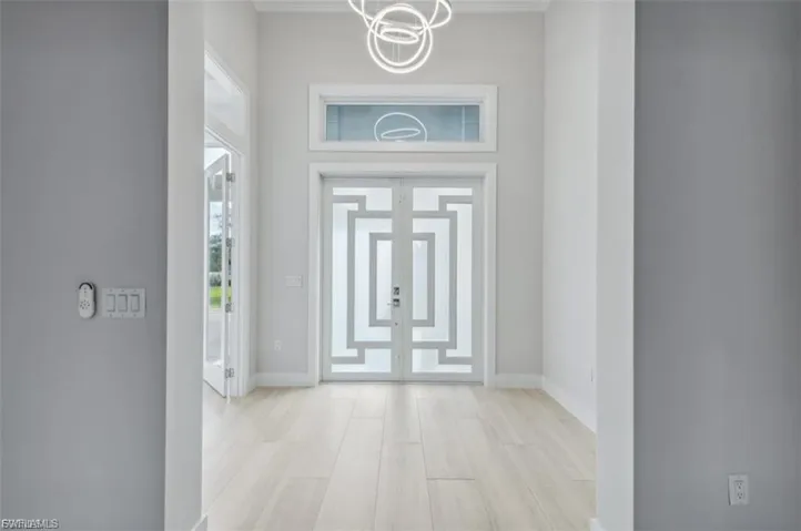 Foyer entrance with light wood finished floors and a high ceiling