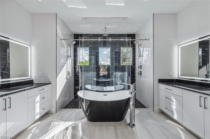 Full bath with a freestanding tub, two vanities, and a stall shower