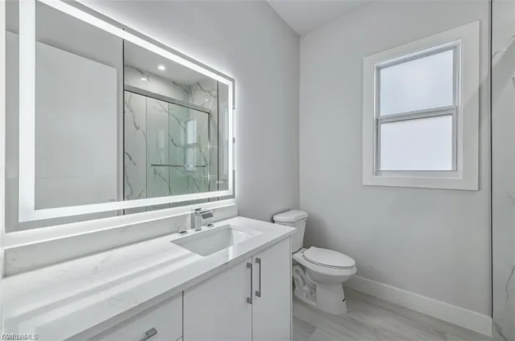 Full bath featuring vanity and a marble finish shower
