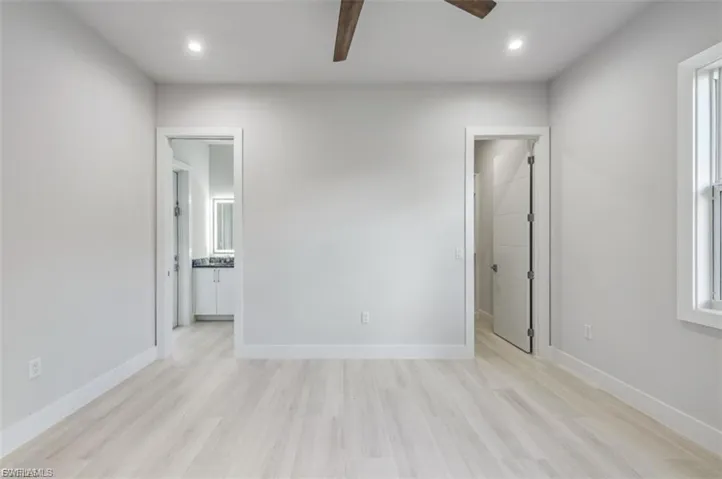 Unfurnished bedroom with connected bathroom, light wood-style flooring, recessed lighting, and ceiling fan