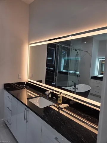 Bathroom with vanity, a stall shower, and a soaking tub
