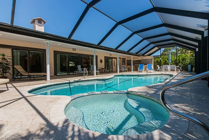 View of swimming pool with a patio area, a pool with connected hot tub, and a lanai