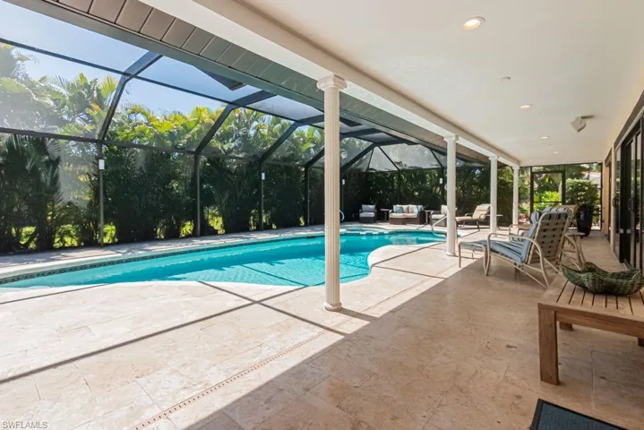 View of swimming pool featuring an outdoor living space, a pool with connected hot tub, a patio, and a lanai