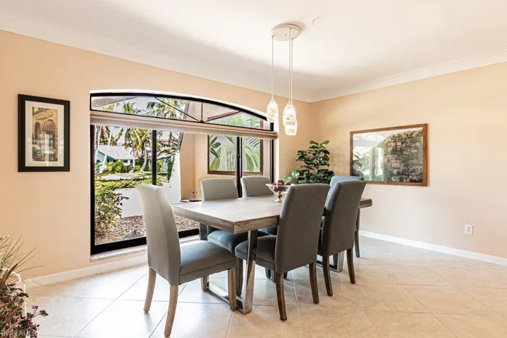 Dining room with crown molding, light tile patterned floors, and baseboards