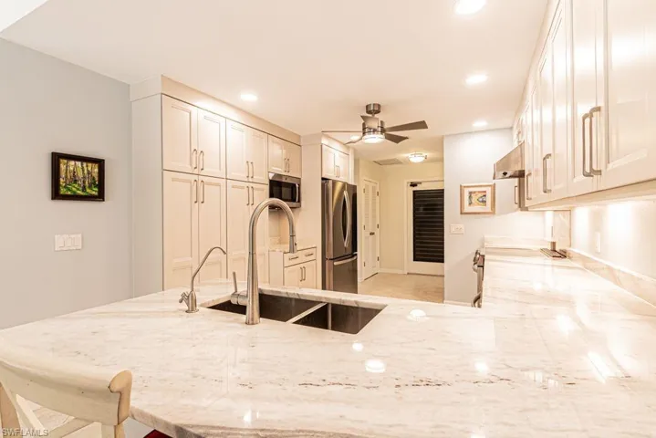 Kitchen featuring light stone counters, recessed lighting, a sink, and stainless steel appliances