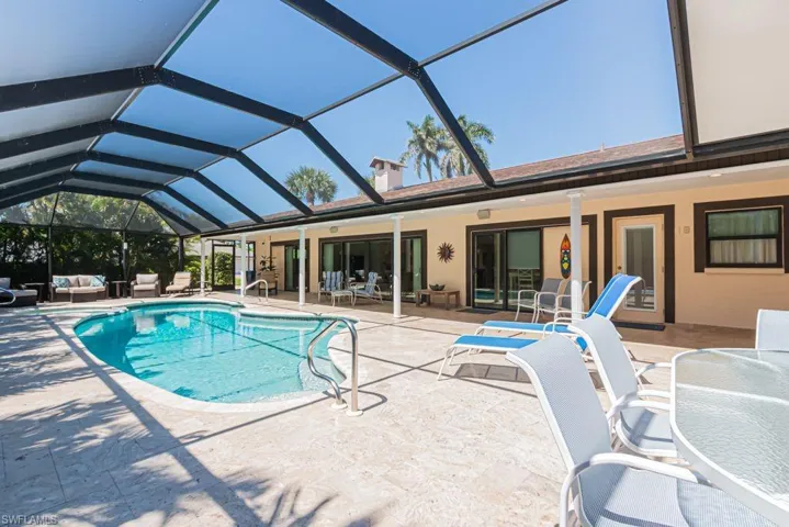 Outdoor pool with a patio area, an outdoor living space, and a lanai