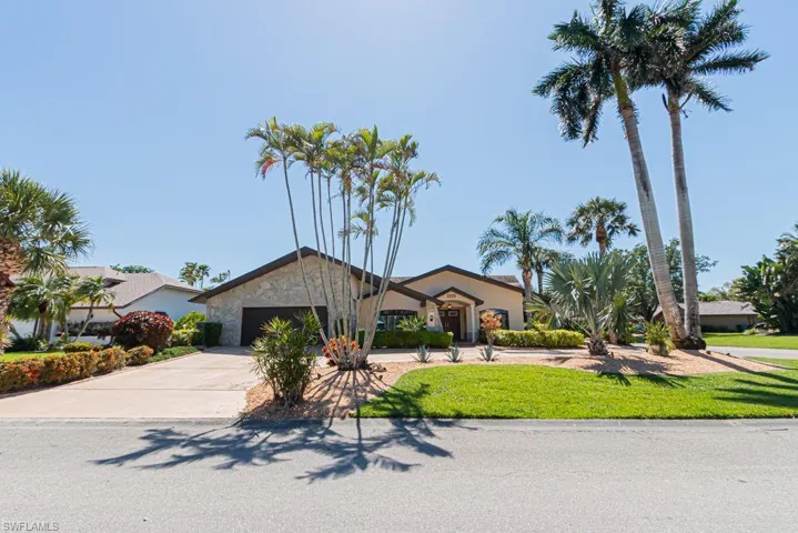 View of front of home with a front lawn, stucco siding, a garage, and concrete driveway