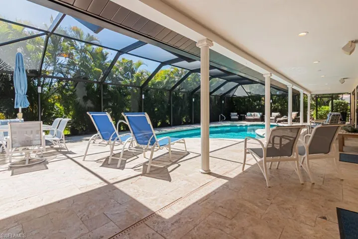 Outdoor pool with a patio area, an outdoor living space, and glass enclosure