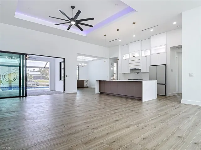 Kitchen with freestanding refrigerator, modern cabinets, white cabinetry, a raised ceiling, and open floor plan