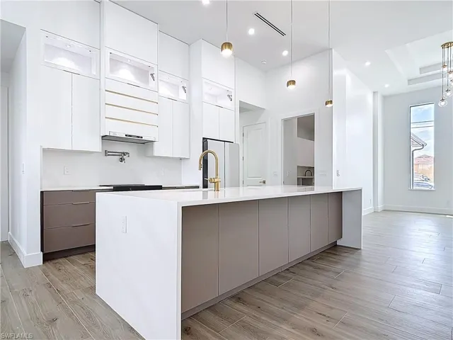 Kitchen featuring light wood-type flooring, modern cabinets, light countertops, and white cabinetry