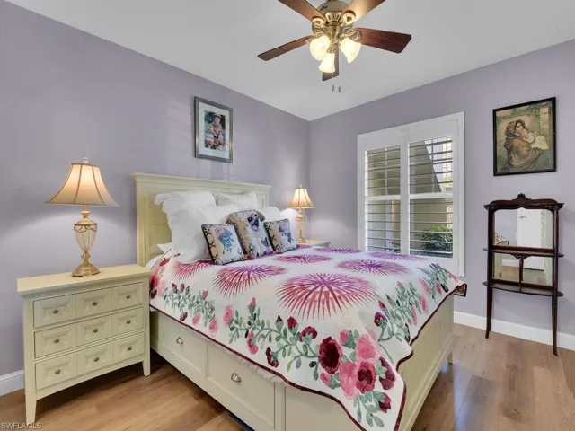 Bedroom with light wood-style flooring, baseboards, and a ceiling fan