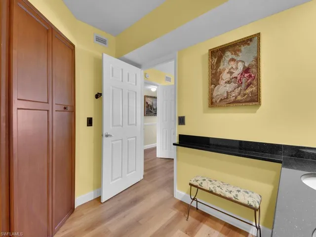 Hallway featuring baseboards, visible vents, and light wood-style floors