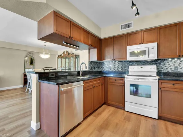 Kitchen with white appliances, visible vents, a sink, and light wood finished floors