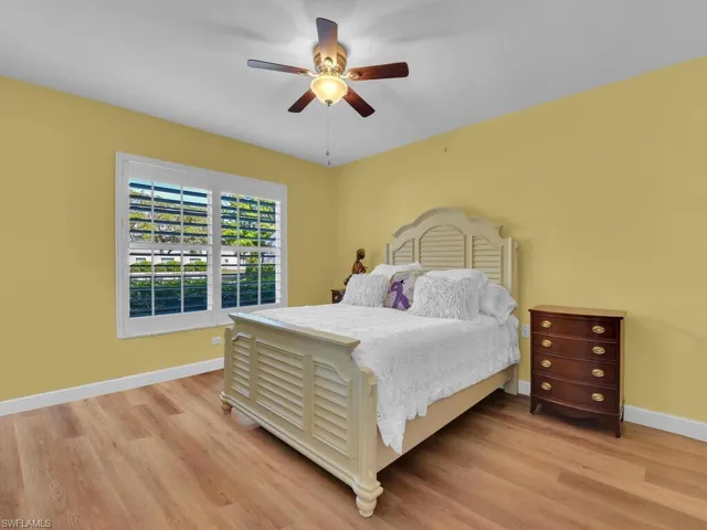 Bedroom featuring light wood finished floors, ceiling fan, and baseboards