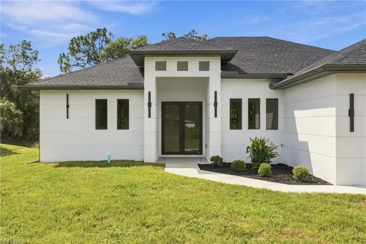 Contemporary stucco exterior with a gray shingle roof