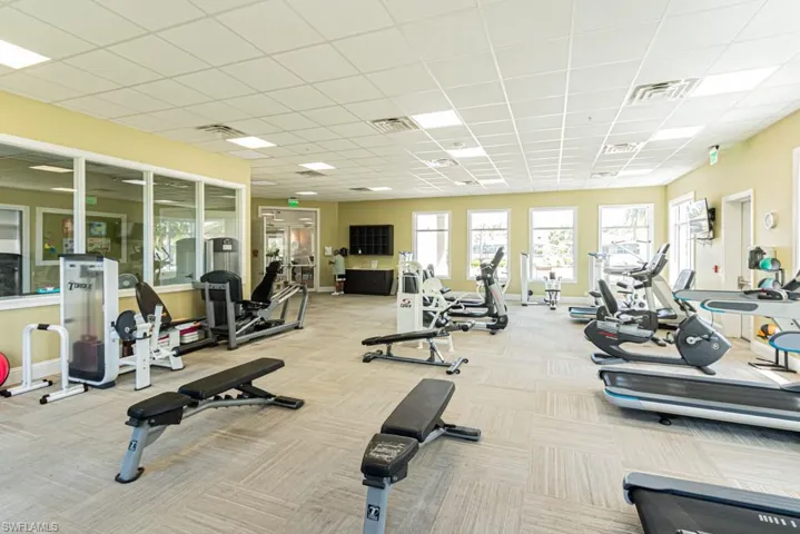 Workout area featuring carpet flooring and a drop ceiling