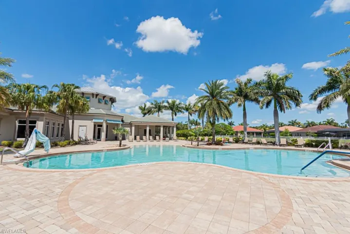 Community pool with a patio area and fence