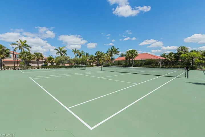 View of tennis court featuring fence and community basketball court