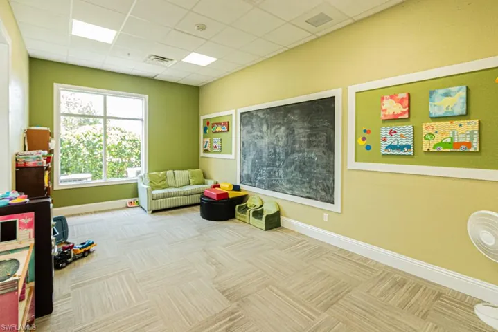 Rec room with carpet flooring, baseboards, and a drop ceiling