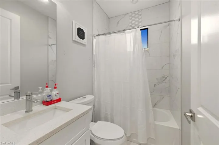 Full bathroom with shower / bath combo and vanity