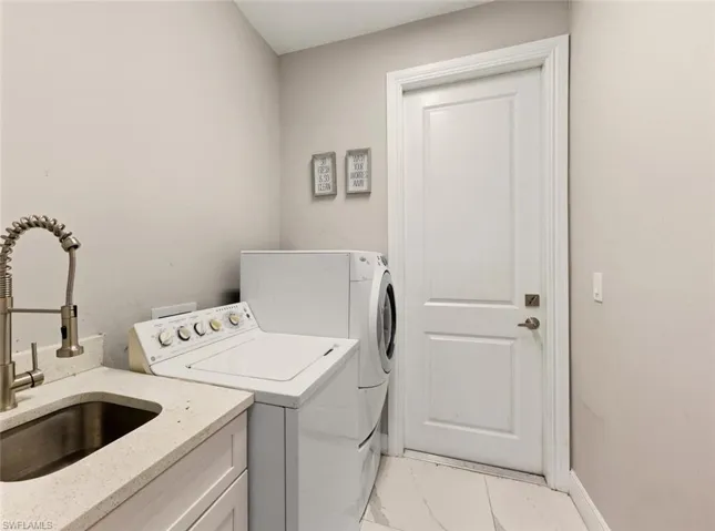 Laundry room with separate washer and dryer and light marble finish flooring