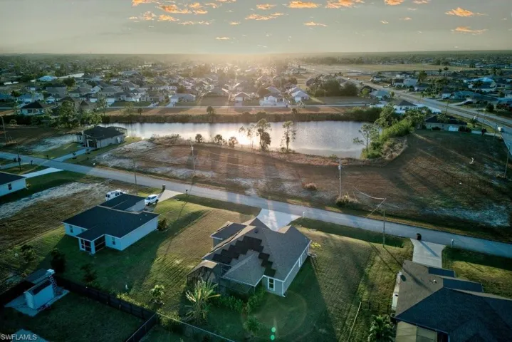 Aerial view at dusk featuring a water view