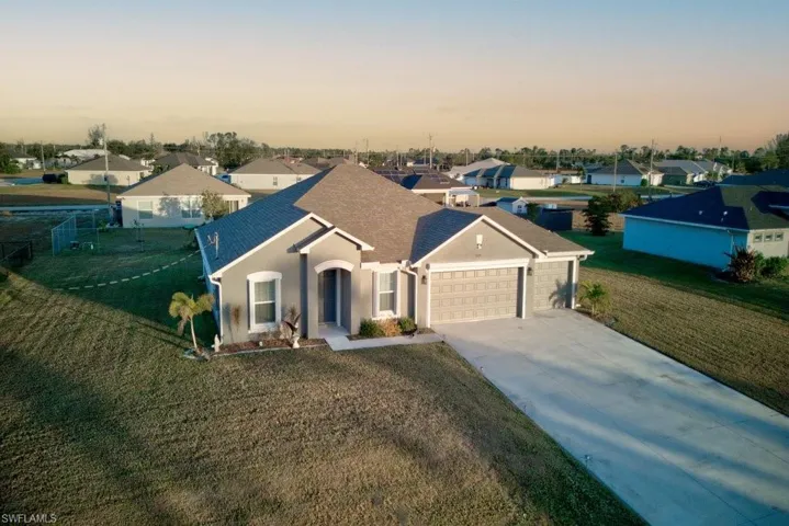 View of front facade featuring a yard and a garage