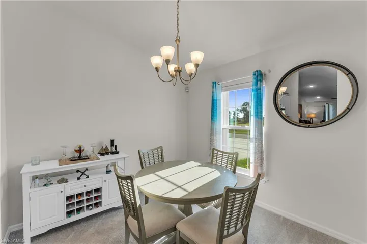 Carpeted dining room featuring a wealth of natural light and a chandelier