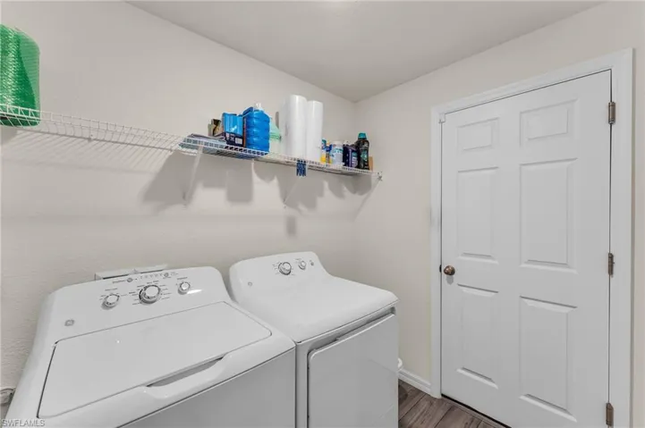 Washroom featuring washing machine and clothes dryer and wood-type flooring