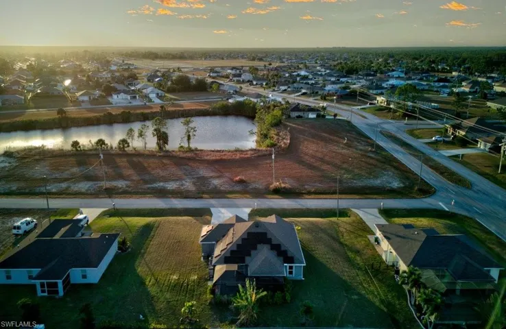 Aerial view at dusk featuring a water view