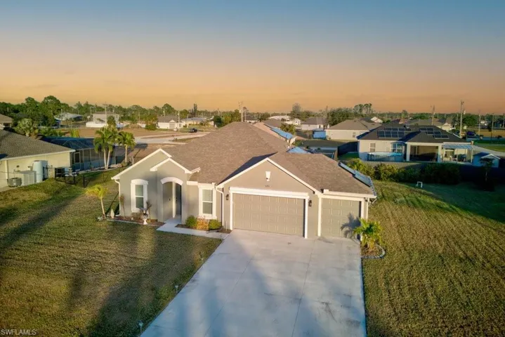 View of front of home featuring a yard and a garage