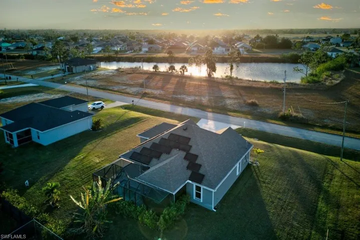 Aerial view at dusk featuring a water view