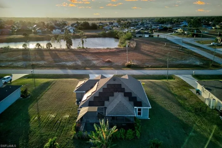 Aerial view at dusk featuring a water view