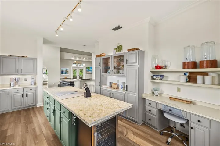 Kitchen featuring a center island, gray cabinets, light wood-type flooring, and crown molding