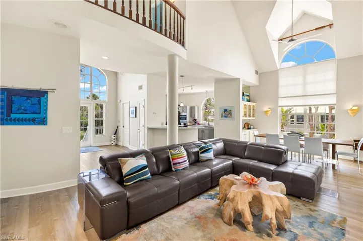 Living room with high vaulted ceiling and light wood-style flooring