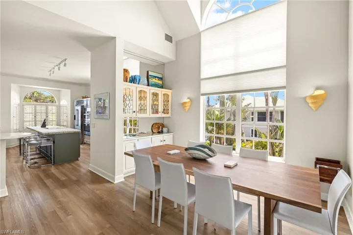 Dining room with light wood-type flooring, lofted ceiling, and track lighting