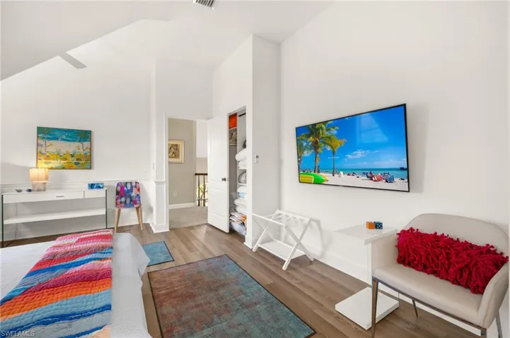 Oversized guest bdroom featuring wood finished floors and a towering ceiling
