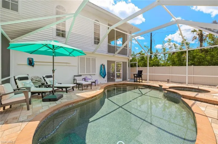 View of swimming pool with lanai, a patio area, a lanai, a pool with connected hot tub.